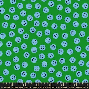 May include: Green fabric with a pattern of light blue smiley faces. The faces are scattered across the fabric, creating a playful and cheerful design. The fabric is suitable for various craft projects.