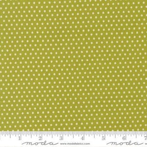 May include: Close-up of a fabric with a repeating pattern of small, white polka dots on a light green background. The fabric has a textured appearance. A ruler is at the bottom of the image, with the word "moda" printed on it.