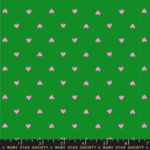 May include: Green fabric with a repeating pattern of small, pink hearts. The hearts are evenly spaced across the surface. The bottom of the fabric has the text "RUBY STAR SOCIETY".