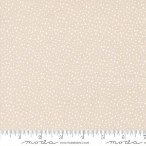 May include: Tan fabric with a pattern of small, irregular white dots. The fabric has a subtle texture and a ruler is visible along the bottom edge, marked in inches. The fabric is suitable for quilting, sewing, or other craft projects.