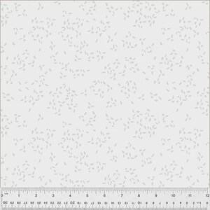 May include: White fabric with a subtle pattern of small, light gray leaf-like shapes scattered across the surface. The fabric has a ruler along the bottom edge, marked in inches and centimeters, indicating measurements.