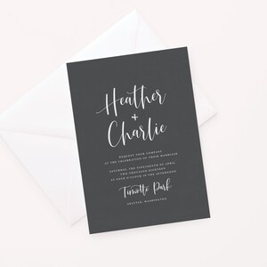 May include: Black wedding invitation with white text. The invitation reads "Heather + Charlie" and includes the date, time, and location of the wedding. The location is listed as "Tinott Park, Seattle, Washington."