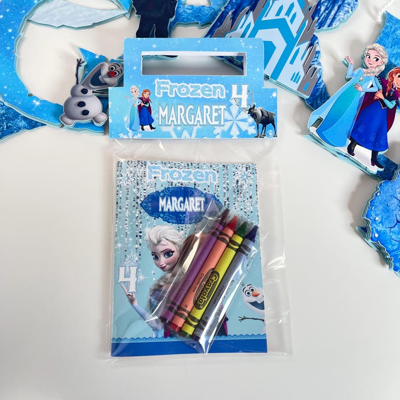 May include: A clear plastic bag containing a Frozen-themed coloring activity set for a 4th birthday. The package features the name MARGARET, images of Elsa, Anna, Olaf, and Sven, and includes four Crayola crayons in purple, orange, yellow, and blue.