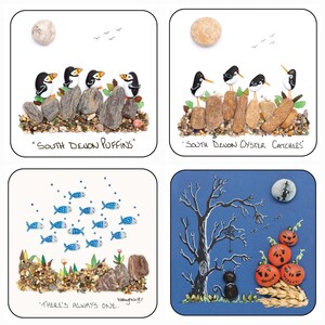 May include: Four square art pieces featuring pebble art. One shows puffins, another oyster catchers, a third depicts fish, and the last has a Halloween theme with pumpkins and a tree. Each piece has text at the bottom.