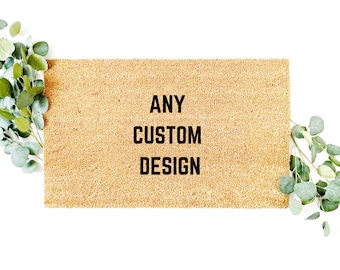 May include: A brown doormat with the text "ANY CUSTOM DESIGN" in black lettering.