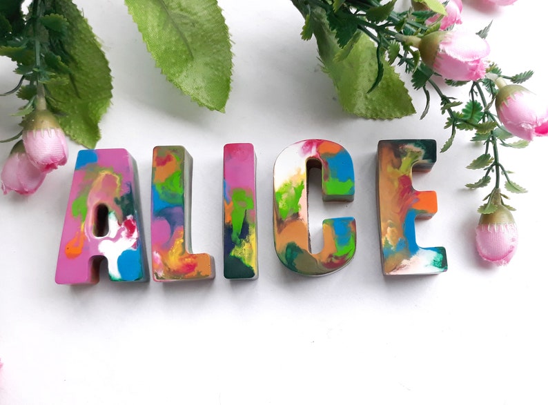 Puede incluir: Letras coloridas, multicolores y texturizadas que deletrean el nombre "ALICE" en una fuente caprichosa. Las letras est&aacute;n hechas de cera y tienen un aspecto &uacute;nico y hecho a mano.