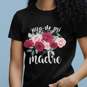 May include: Black t-shirt with a floral design and the text "Hija de mi madre" in white.