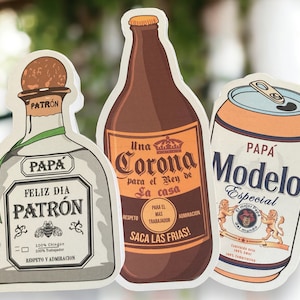 May include: Three illustrated beverage bottles with a Father's Day theme. The bottles are labeled "Corona", "Modelo", and "Patron". The Corona bottle is brown with a gold crown and the text "Una Corona para el Rey de la casa". The Modelo bottle is white with a gold label and the text "Papa Modelo Especial". The Patron bottle is white with a green label and the text "Feliz Dia Patron".