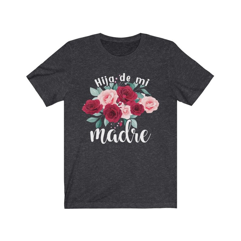 May include: Dark heather grey t-shirt with a floral design and the text "Hija de mi madre" in white.