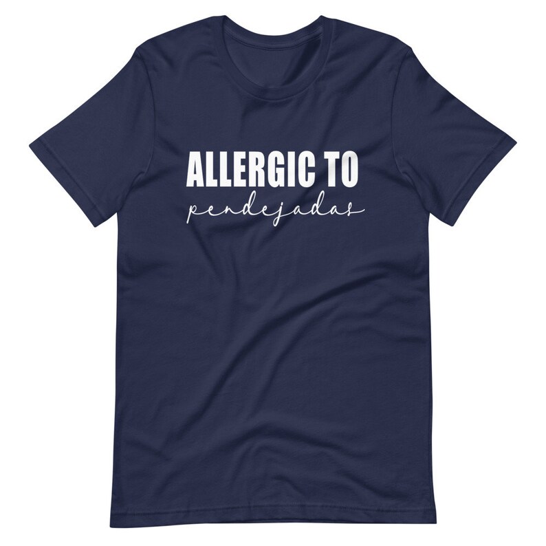 May include: A navy blue t-shirt with white text that reads "ALLERGIC TO pendejadas".