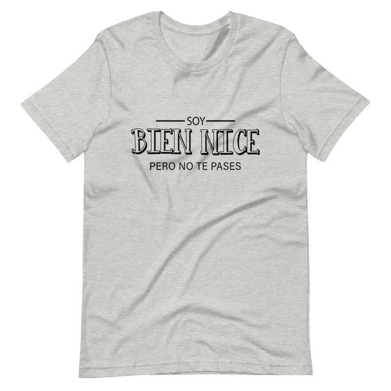 K&ouml;nnte beinhalten: Ein graues T-Shirt mit schwarzem Text, der "Soy Bien Nice Pero No Te Passes" lautet.