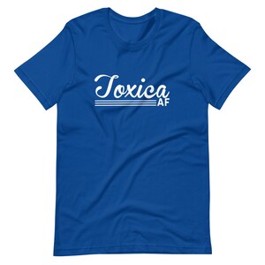 May include: A royal blue t-shirt with white text that reads "Toxica AF" in a retro script font.