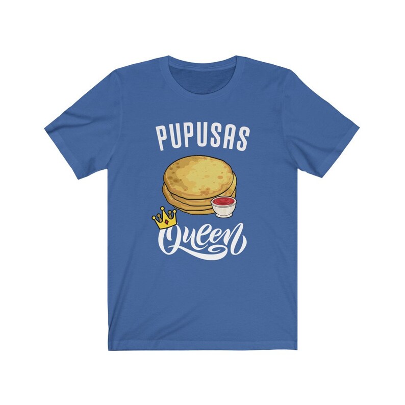 Puede incluir: Una camiseta azul real con el texto "Pupusas Queen" en letras blancas. Una imagen de dibujos animados de pupusas con un lado de salsa est&aacute; por encima del texto. Una corona dorada est&aacute; a la izquierda del texto.