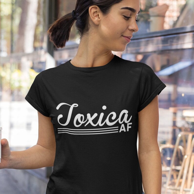 May include: Black t-shirt with white text that reads "Toxica AF" in a retro font.