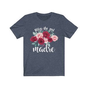 May include: A navy blue t-shirt with a floral design and the text "Hija de mi madre" in white.