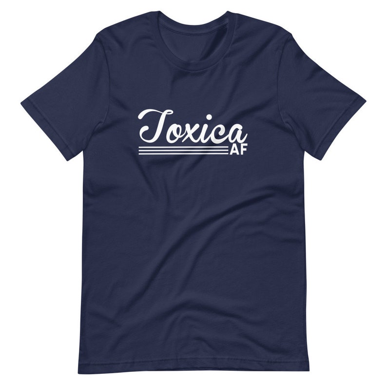 May include: A navy blue t-shirt with white text that reads "Toxica AF" in a retro font.