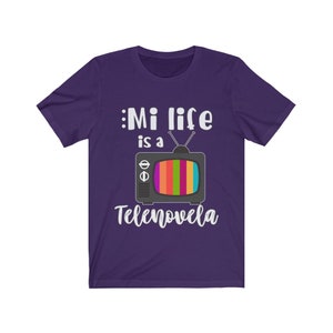 May include: Purple t-shirt with a white graphic of a vintage television with the text "Mi life is a Telenovela".