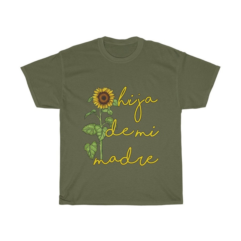 Puede incluir: Una camiseta verde con un gr&aacute;fico de girasol y el texto "hija de mi madre" en amarillo.
