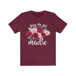 May include: Burgundy t-shirt with a floral design and the text "Hija de mi madre" in white.