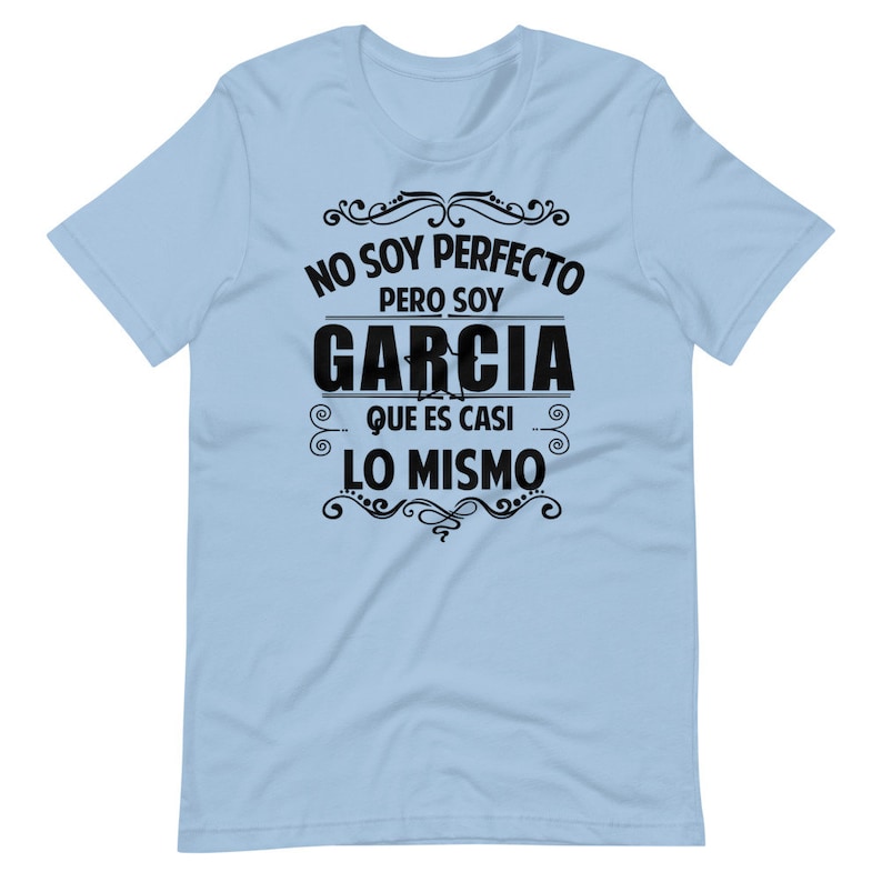 May include: Light blue t-shirt with black text that reads "No soy perfecto pero soy Garcia que es casi lo mismo" which translates to "I am not perfect but I am Garcia which is almost the same".
