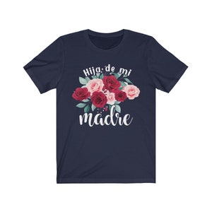 May include: Navy blue t-shirt with a floral design and the text "Hija de mi madre" in white.
