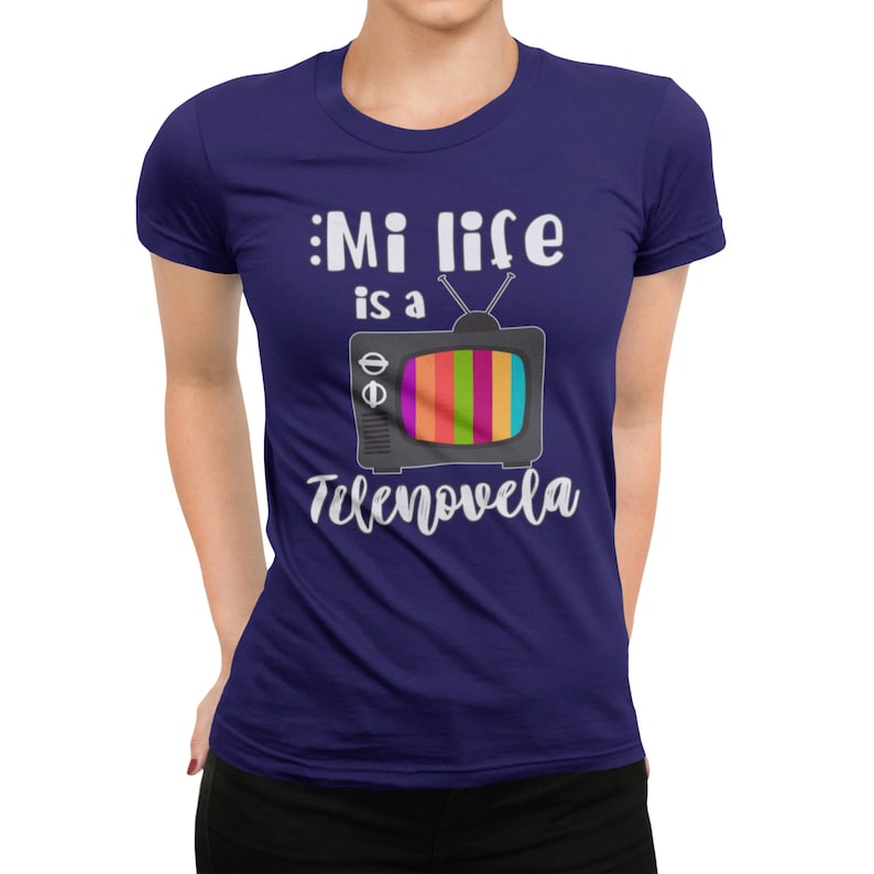May include: A navy blue t-shirt with a white graphic of a retro television with the text "Mi life is a telenovela".