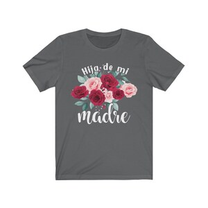 May include: A dark gray t-shirt with a floral design and the text "Hija de mi madre" in white.