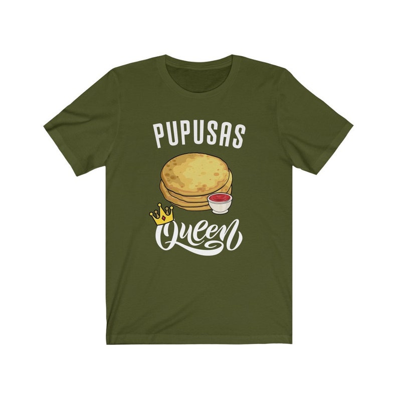 Puede incluir: Camiseta verde con el texto "Pupusas Queen" en blanco. Una imagen de dibujos animados de pupusas con un lado de salsa est&aacute; por encima del texto. Una corona dorada est&aacute; a la izquierda del texto.