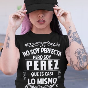 May include: Black t-shirt with white text that reads "NO SOY PERFECTA PERO SOY PEREZ QUE ES CASI LO MISMO". The text is surrounded by decorative swirls.
