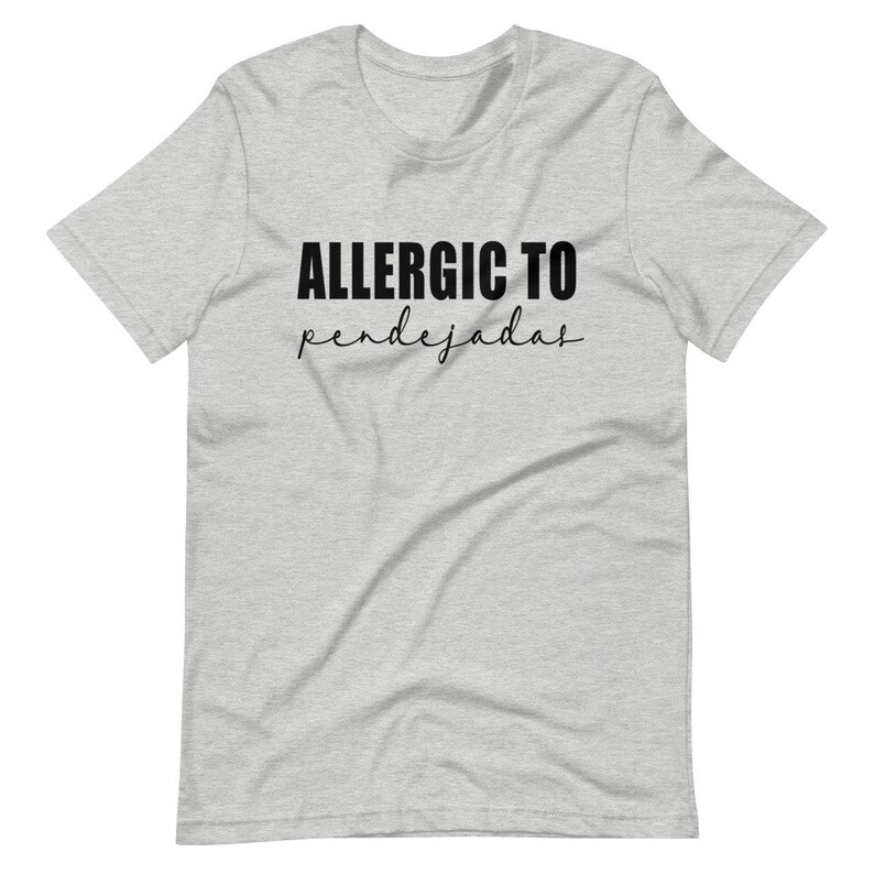 May include: A heather grey t-shirt with black text that reads "ALLERGIC TO pendejadas".