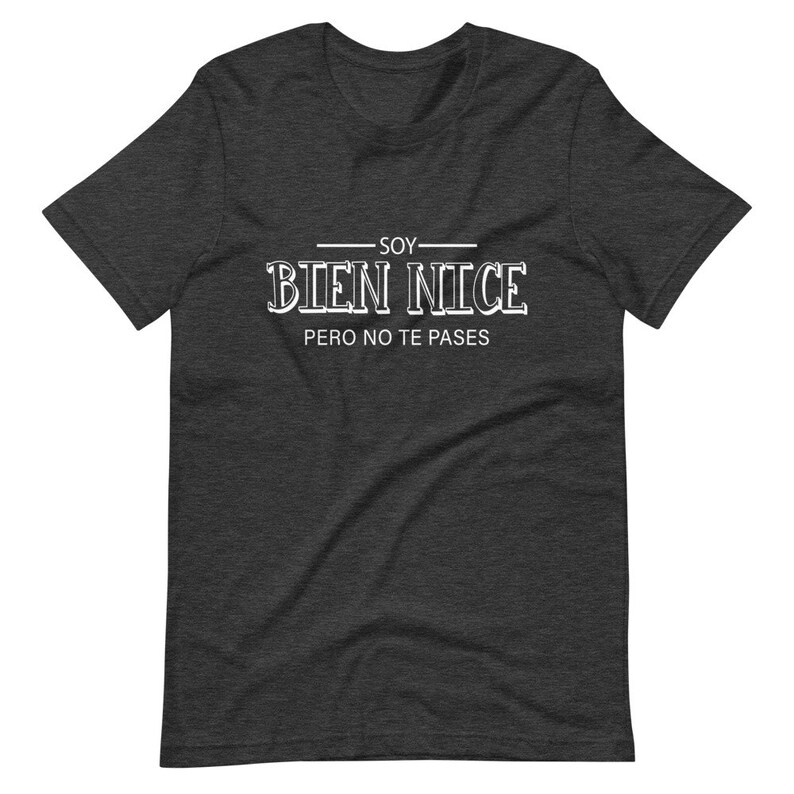 K&ouml;nnte beinhalten: Ein dunkelgraues T-Shirt mit wei&szlig;em Text, der "Soy Bien Nice Pero No Te Passes" lautet.
