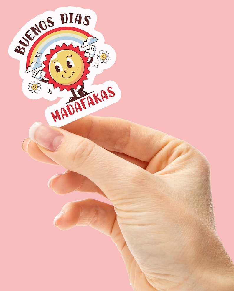Op de afbeelding: Een witte sticker met een cartoonzon, regenboog en wolken. De tekst op de sticker luidt "Buenos Dias Madafakas".