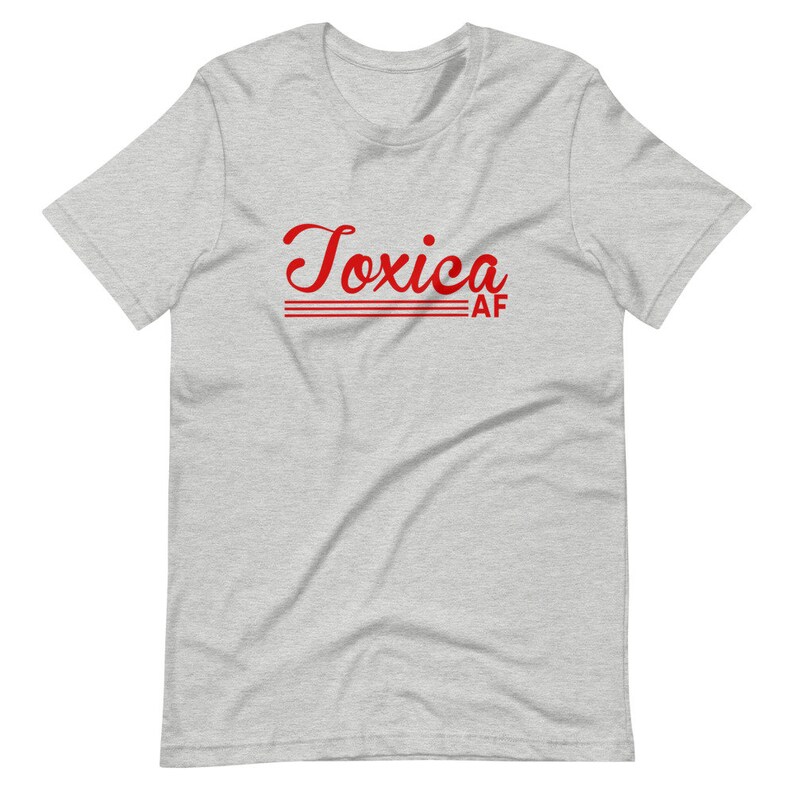 May include: A heather grey t-shirt with the text "Toxica AF" in red cursive lettering.