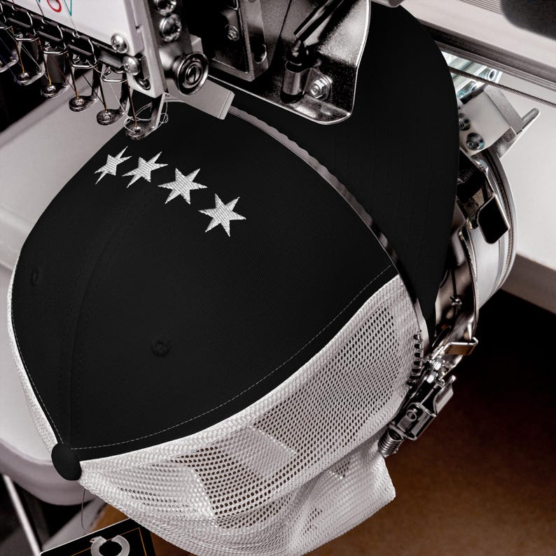 May include: A black and white trucker hat with a white mesh back and five white stars embroidered on the front.