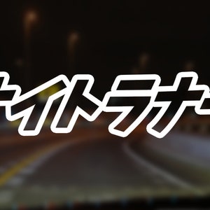 May include: The image features the Japanese text "ナイトラナー" in a white, outlined font. The text is set against a blurred background of a road at night, with streetlights visible. The overall theme suggests a night-time activity.
