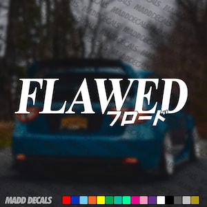Op de afbeelding: Witte "FLAWED" sticker met Japanse karakters, afgebeeld op de achterkant van een blauwe auto. De afbeelding toont het woord "FLAWED" in een vetgedrukte letter, met Japanse karakters eronder. De onderkant van de afbeelding toont de tekst "MADD DECALS" en een kleurenpalet.