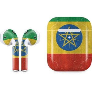 Puede incluir: Un conjunto de auriculares inalámbricos con una funda que presenta la bandera de Etiopía. La funda es amarilla con una franja roja en la parte inferior y una franja verde en la parte superior. La bandera tiene una estrella azul con un círculo blanco en el centro.