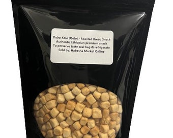 May include: A black resealable bag filled with small, square-shaped, light brown, roasted bread snacks. The bag has a label that reads "Dabo Kolo (Qolo) - Roasted Bread Snack, Authentic Ethiopian premium snack, To preserve taste seal bag & refrigerate, Sold by: Habesha Market Online."