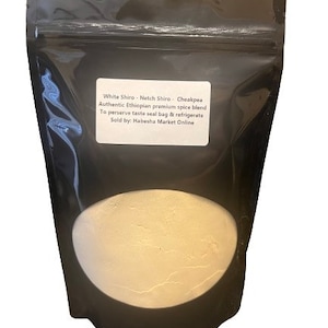 May include: A black resealable bag filled with white Shiro, a traditional Ethiopian spice blend. The bag has a label that reads "White Shiro - Netch Shiro - Cheakpea Authentic Ethiopian premium spice blend To preserve taste seal bag & refrigerate Sold by: Habesha Market Online"