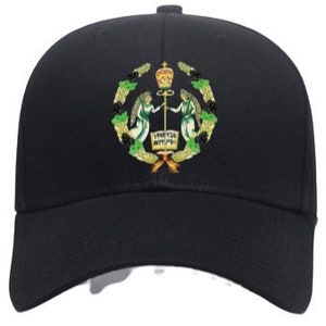 May include: A black baseball cap with an embroidered emblem featuring two angels holding a staff with a crown on top. The emblem is surrounded by a wreath of green leaves.