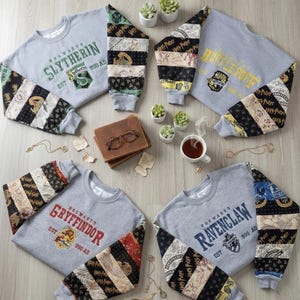 May include: Four gray sweatshirts with Hogwarts house emblems and text. Sleeves feature patchwork fabric with Harry Potter-themed patterns. The sweatshirts are arranged with accessories like a book, glasses, and small plants.