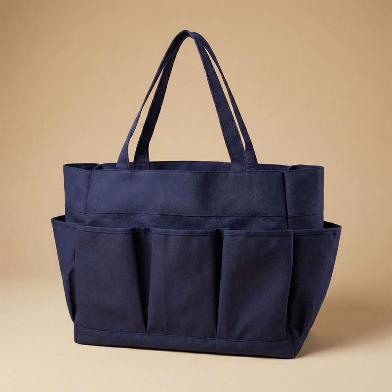 May include: A navy blue tote bag with multiple exterior pockets and two long handles. The bag is made of a sturdy fabric and is designed for carrying various items. The bag has a rectangular shape and is suitable for shopping or everyday use.