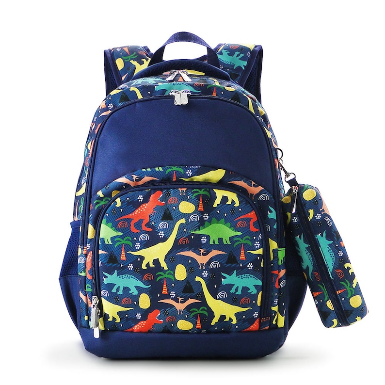May include: A navy blue backpack and matching pencil case set. The backpack features a colorful dinosaur pattern with red, yellow, green, and blue dinosaurs, palm trees, and geometric shapes. The backpack has a front pocket, side mesh pocket, and a top handle.