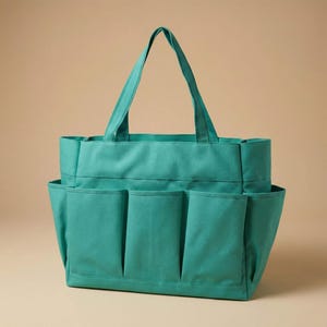 May include: A teal canvas tote bag with multiple exterior pockets. The bag has a rectangular shape with a wide opening and two handles for carrying. The pockets are vertically oriented and provide additional storage space.