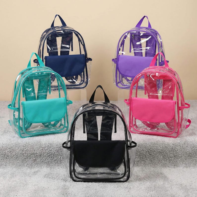 May include: Five clear backpacks with colored accents. The backpacks have a transparent body with colored front pockets and trim in teal, navy, purple, pink, and black. Each backpack has a top handle and adjustable straps.