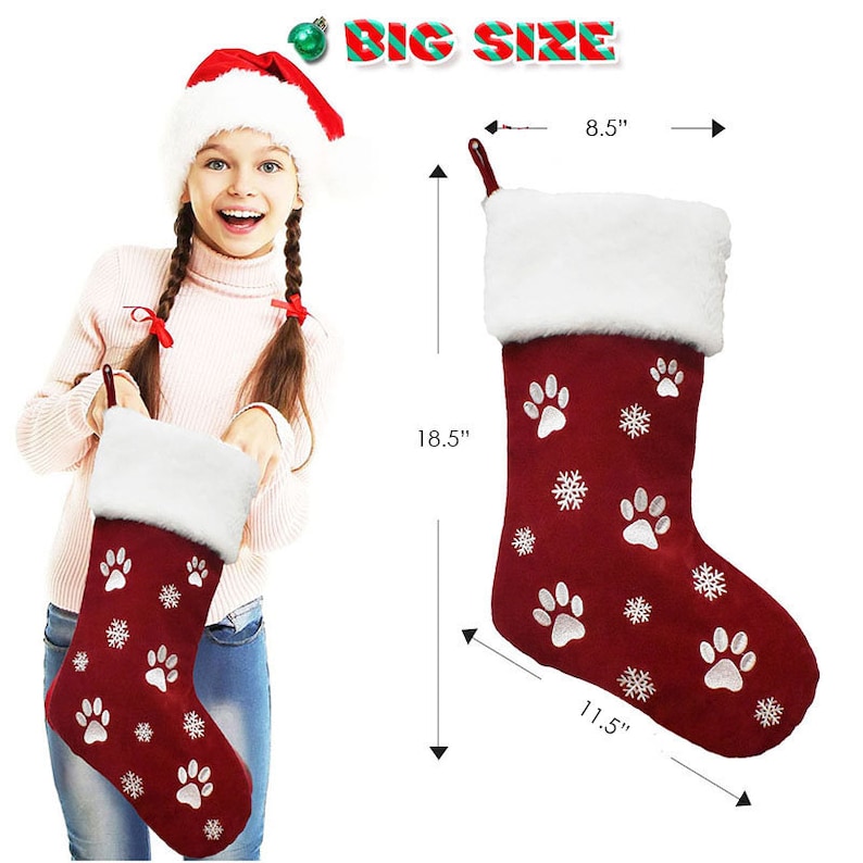 May include: A burgundy Christmas stocking with white paw prints and snowflakes, measuring 18.5 inches long, 11.5 inches wide, and 8.5 inches across the top. The stocking has a white faux fur cuff and a loop for hanging.