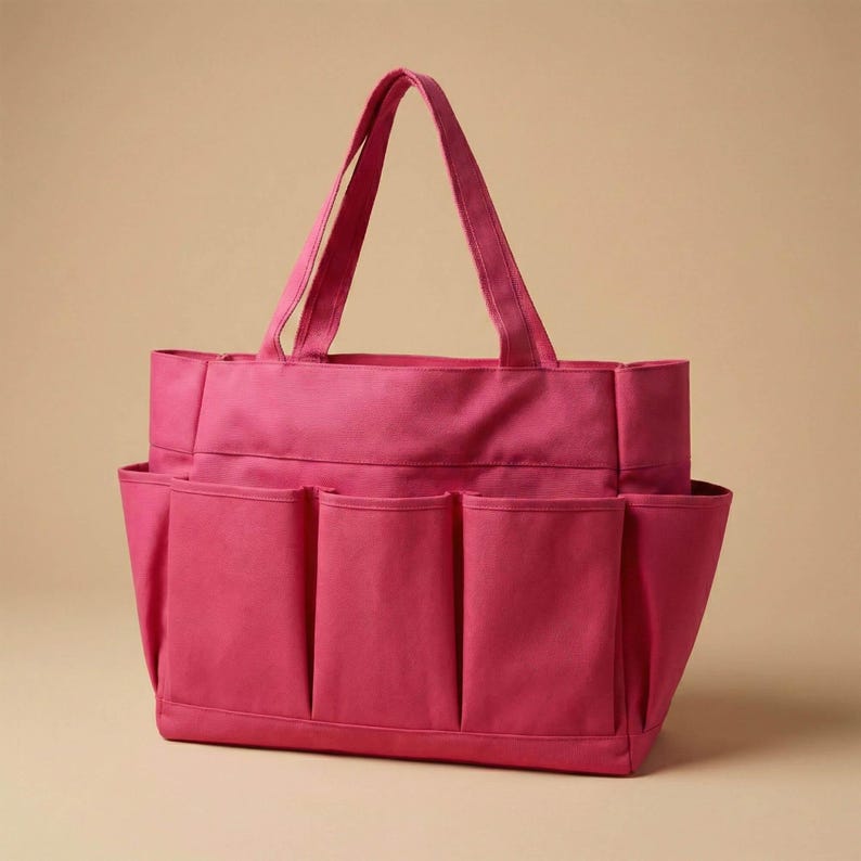 May include: A magenta tote bag with multiple exterior pockets. The bag has two handles for carrying and is made of a sturdy fabric. The design includes several pockets on the outside for easy access to items.