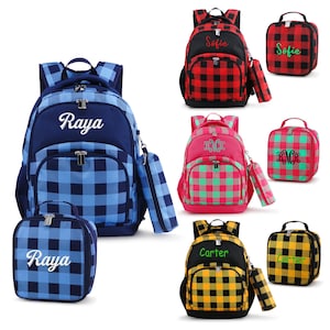 May include: Set of four personalized backpacks and lunch bags with plaid patterns. The backpacks are blue, red, pink, and yellow with black accents. The lunch bags match the backpacks. Each backpack and lunch bag has a name embroidered on it: Raya, Sofie, Carter, and a monogram.