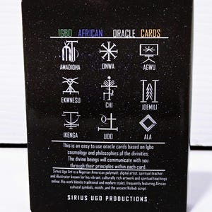 May include: Black box of Igbo African Oracle Cards. The box features white symbols and text, including "IGBO AFRICAN ORACLE CARDS" and the Sirius Ugo Productions logo. The text describes the cards' purpose and the artist's background.