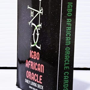 May include: A black box of Igbo African Oracle Cards. The box features green and red text with the words "Igbo African Oracle" and "Daily Living Deck". The box has a starry background and a green and white graphic.